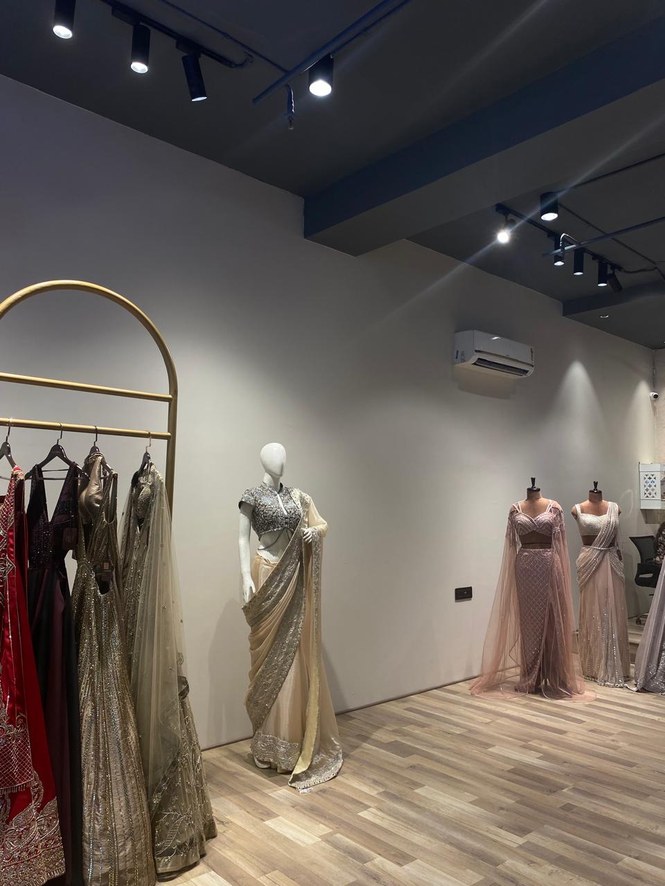 Dress store interior with mannequins wearing dresses and a rack of clothes