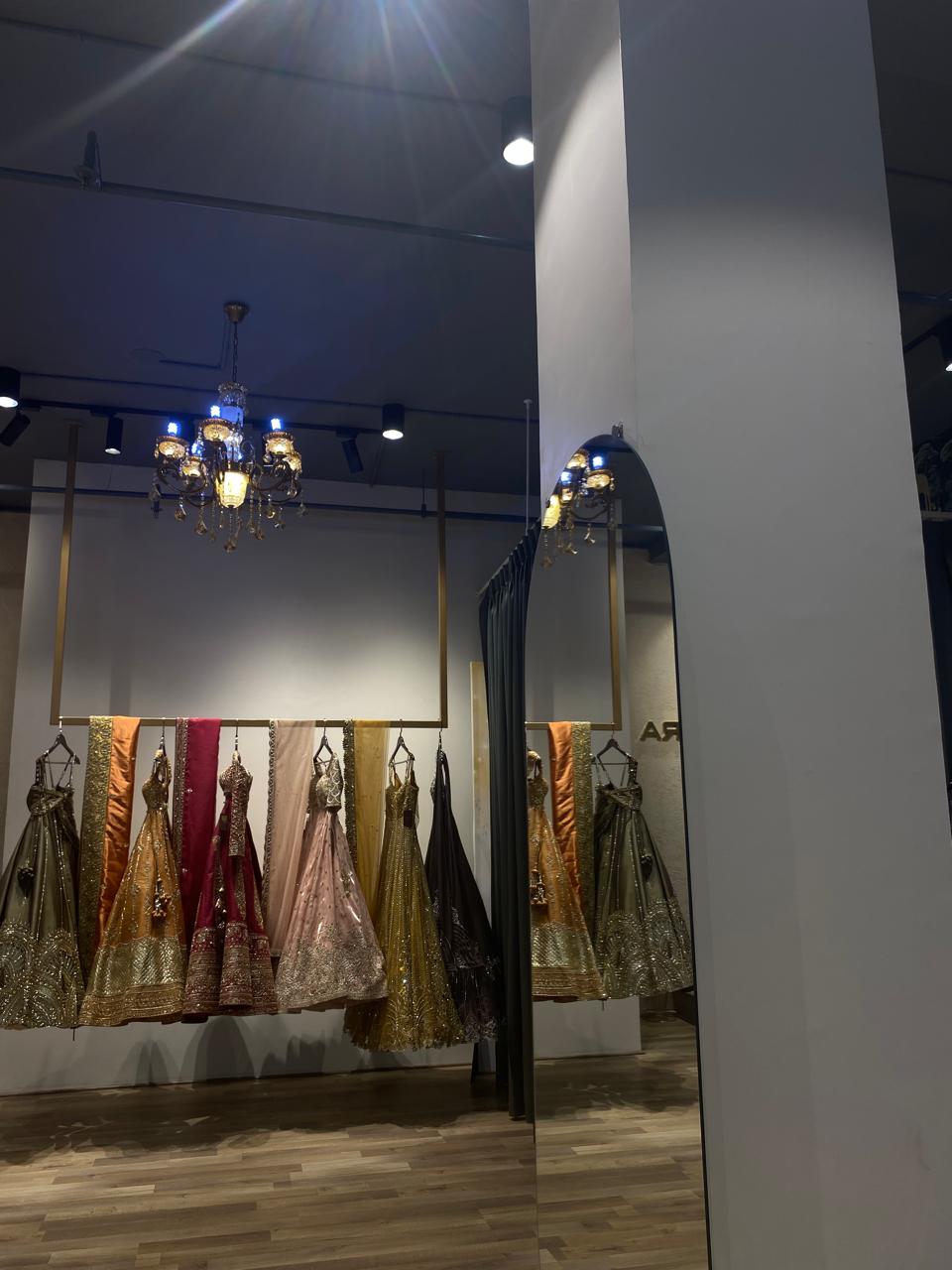 Dresses on display in a store with a mirror reflecting the interior